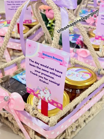 A close-up of a unicorn jute basket, highlighting the "Unicorn Dreams" thank you card and the custom-labeled treat jars.