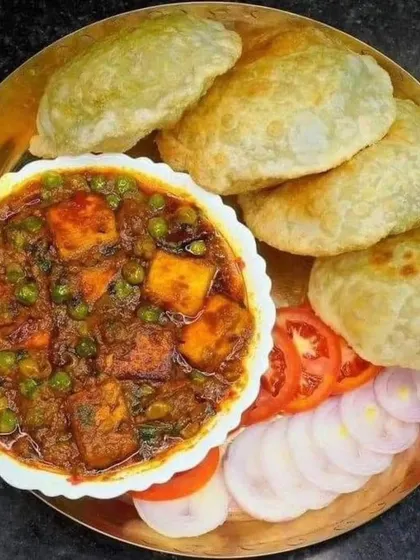 A delightful meal of Matar Paneer served with hot, fluffy pooris and a side of fresh salad. This is a festive and indulgent combination that I love to prepare for special requests.