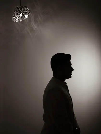 A creative silhouette of the groom, his profile outlined against a single spotlight, creating a moody and sophisticated portrait.
