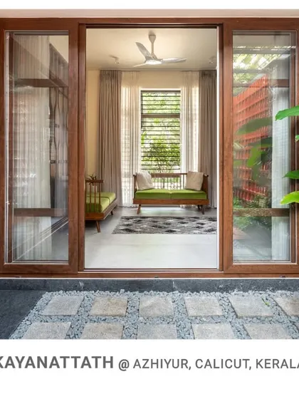 Looking from the courtyard back into the living room of Kayanattath House, this image highlights how the design creates a true indoor-outdoor living experience.