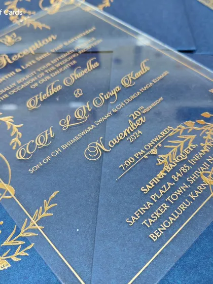 A stunning blue acrylic wedding reception invitation. The gold lettering on the clear acrylic creates a luxurious and modern effect, especially against the rich blue background.