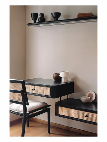 This guest bedroom features a sleek, floating study desk and shelf unit in black burnt wood with cane drawer fronts. The design is minimal and space-saving, creating a functional workspace without overwhelming the room.