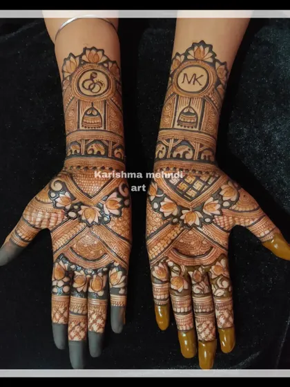 A beautiful engagement mehendi featuring the couple's initials, "M" and "K", in stylish monograms. The design also includes symbols of commitment like temple domes and elephants, perfect for celebrating a new beginning.