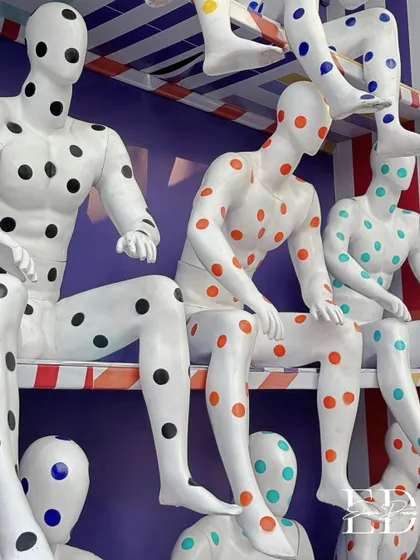 A detailed shot of the colorful, polka-dotted mannequin installation, highlighting the playful yet artistic execution.