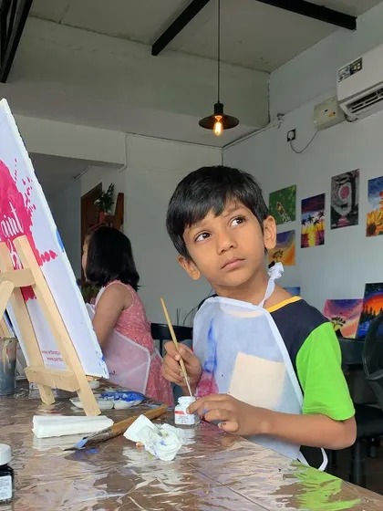 A young artist deep in thought at one of our kids' workshops. We provide a supportive and encouraging environment for kids to explore their creativity.