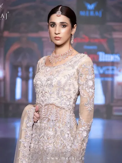 A symphony of grace and grandeur. This light peach tail peplum Indo-western is adorned with intricate hand embellishments, the epitome of regal charm.