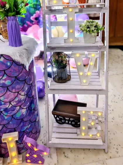 A decorative shelf spelling 'LOVE' with marquee letter's, adding a sweet touch to the mermaid party decor.
