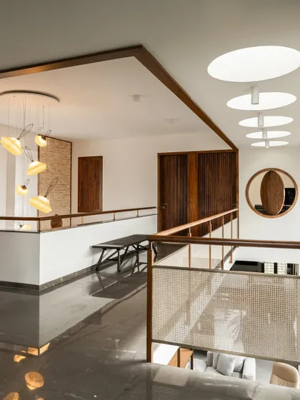 These images show the upper-level bridge and hallway, illuminated by both angled and circular skylights. The combination of different light sources ensures the core of the home is always bright and connected to the time of day.