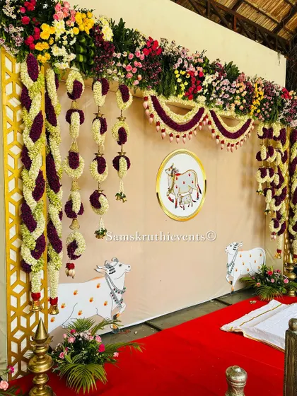 A beautiful backdrop with a custom illustration of a cow and calf, a sacred symbol in our culture. The design is framed by intricate floral garlands, blending artistic and traditional elements perfectly.