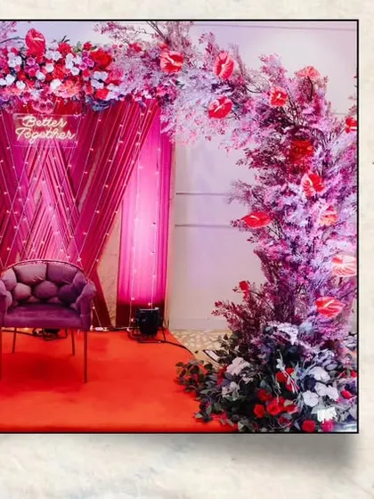 A glimpse of the decor elements for Gladys and Jerin's reception. The photo booth featured a dramatic floral arch in shades of purple and red, while the main hall was set up with elegant red and gold seating arrangements.