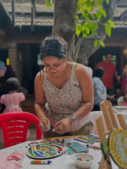Here I am at a party, helping the kids get started on their mosaic art. I provide a wide range of colorful tiles so they can let their imaginations run wild.