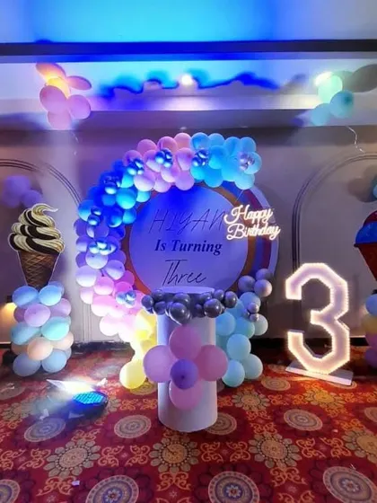 An ice cream-themed third birthday with pastel balloons and a light-up number '3'.