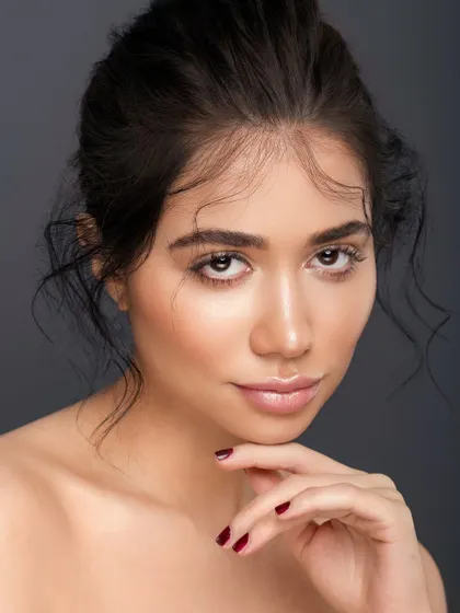 A simple, elegant pose with the hand gently resting on the chin. This classic portrait composition is clean and sophisticated, allowing the model's natural beauty to be the sole focus.