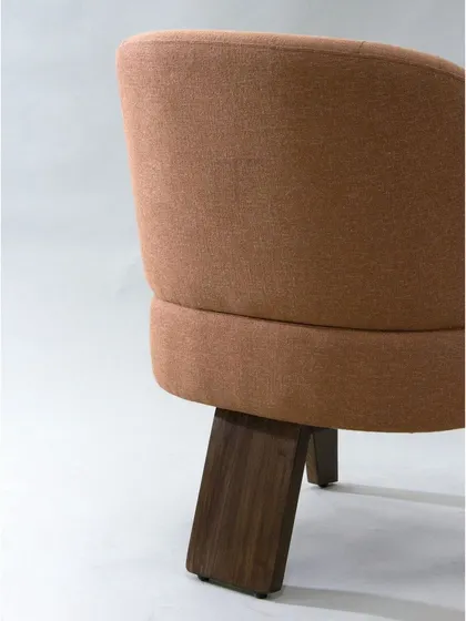 The back view of the modern armchair shows the unique shape of its legs and the seamless upholstery work.