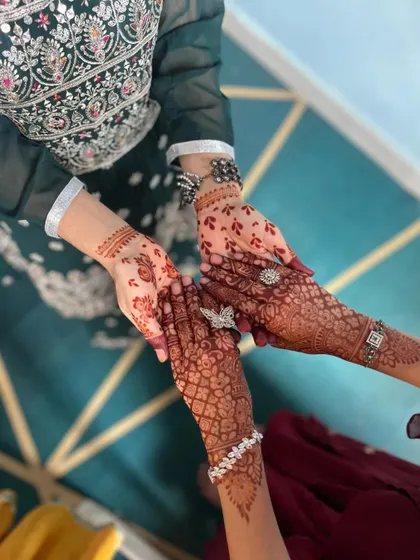 A beautiful photo of friends comparing their henna stains. The deep red color is the sign of good quality henna and care.