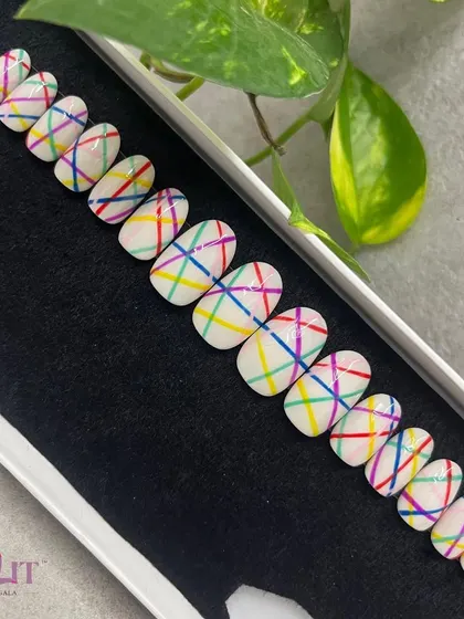 Lines and colors make for a playful design. This press-on set features a clean white base with a crisscross pattern of bright, colorful lines for a fun, geometric look.