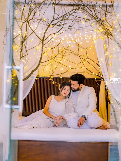 A peaceful moment shared by a couple on a beautifully lit indoor bed set. The warm fairy lights create a cozy and romantic atmosphere for this pre-wedding photo.
