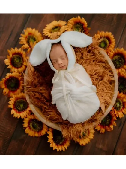 Our littlest bunny surrounded by sunflowers. The combination of the cute costume and bright flowers makes for a cheerful and unforgettable newborn photo.