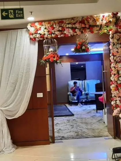 A floral arch decorating the entrance to a room or a private section. The use of birdcages adds a whimsical touch to the classic flower arrangement.