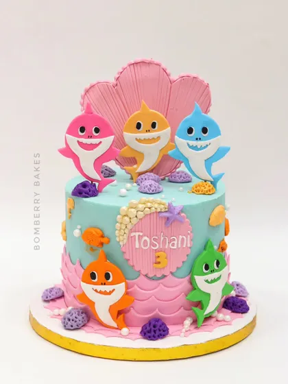 A vibrant Baby Shark cake for a 3rd birthday, with the whole shark family swimming around an underwater scene.
