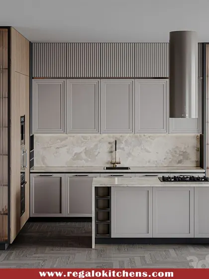 A sophisticated kitchen design with grey shaker cabinets and fluted glass tall units. The island hob is complemented by a sleek, cylindrical chimney. This kitchen perfectly balances classic and modern elements.