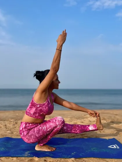 A challenging one-legged squat, a variation of Padangusthasana, requires immense focus and balance. The beach provides an uneven surface that deepens the practice, teaching me to find stability amidst change.