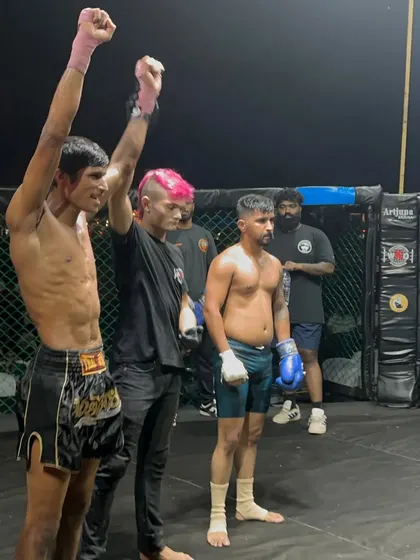 A fighter's hand is raised by the referee. This is the official declaration of a well-earned victory.