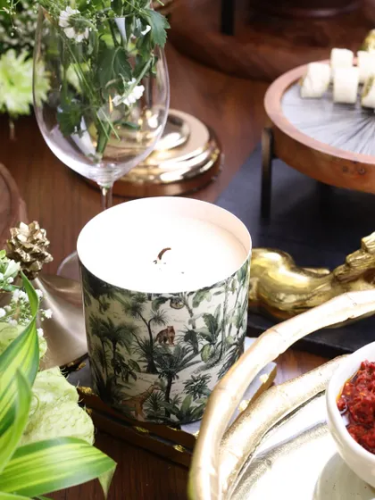 Our jungle-print scented candle, styled on a festive tablescape. Its subtle fragrance and beautiful design add to the overall ambiance of the gathering.