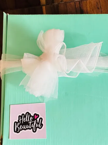 The farewell gift box elegantly wrapped with a white tulle bow, ready to be presented.