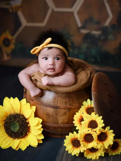 An awake and curious baby peeking out of our wooden barrel prop. We capture both sleeping and awake moments during our sessions.