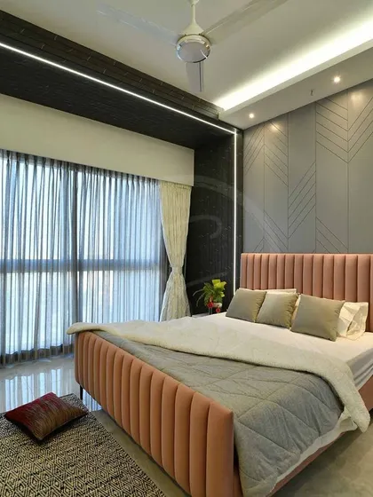 This shot of the completed bedroom focuses on the natural light flooding in from the large window, illuminating the soft textures of the bedding and the rug.