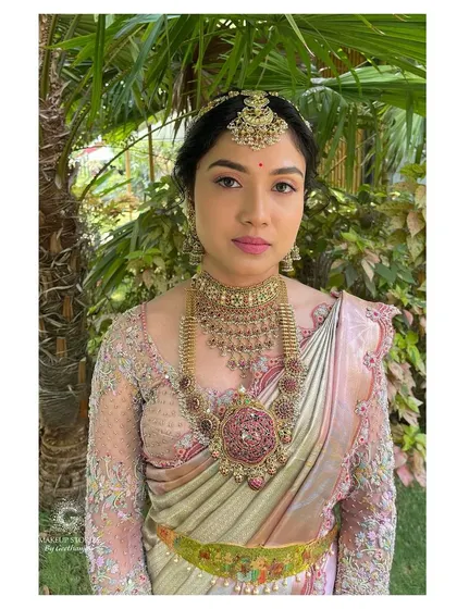 A direct portrait of Drutha. The makeup is perfectly balanced, with attention to her eyes, lips, and glowing skin, all complementing her magnificent jewelry and outfit.