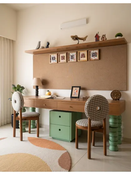 A dedicated study area for two, with a floating wooden desk and quirky chairs supported by green totem-like legs. The large corkboard is perfect for pinning up artwork and dreams.