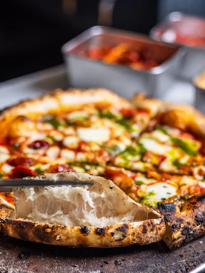 The proof is in the crust. I cut open the edge, or cornicione, to show you the light, airy, and open crumb structure inside. This is the result of proper hydration and a long fermentation process, creating a crust that's as delicious as the toppings.