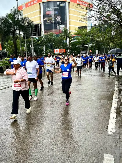 A runner enjoying the race, waving to the camera during the Mumbai Half Marathon.