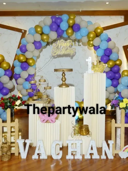 A colorful balloon ring with purple, blue, and gold balloons, creating a festive look for a first birthday.