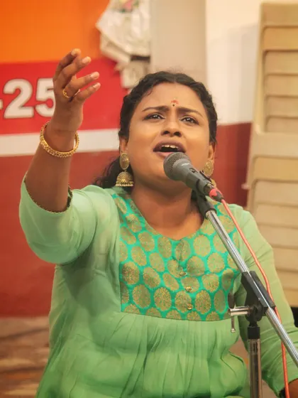 The expression of pure devotion on a student's face as she sings a bhajan at the temple.