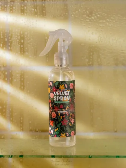 A creative shot of a body spray seen through a glass panel with fake condensation. This technique adds a refreshing and steamy bathroom feel to the image.