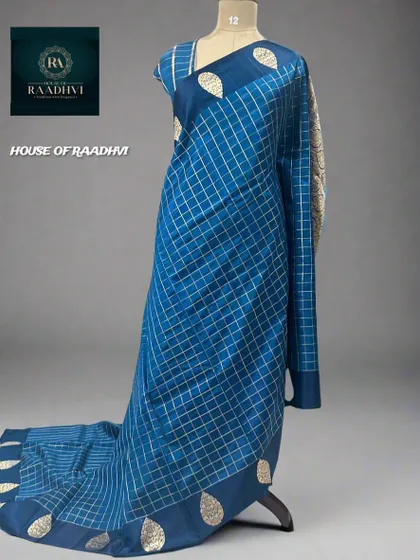 A restocked checks pattern pure Banaras lightweight silk saree in a beautiful peacock blue.
