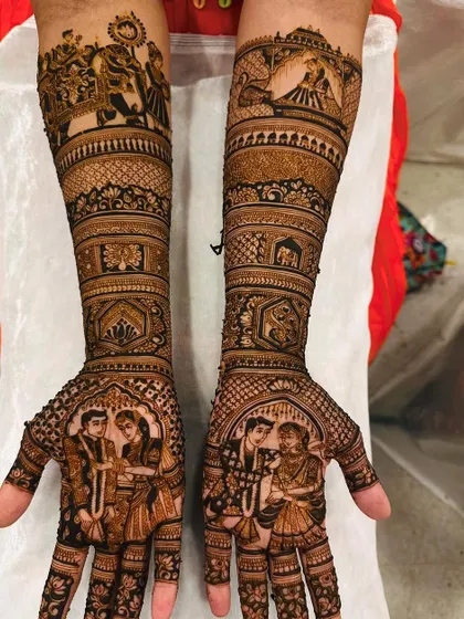 This design beautifully captures the bride and groom in a varmala ceremony portrait on the palms. The forearms depict the baraat procession, complete with elephants and traditional motifs, creating a cohesive wedding theme.