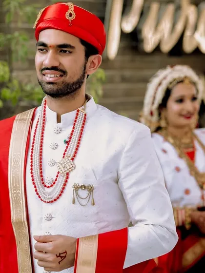 A classic groom-in-the-foreground, bride-in-the-background shot. This creative composition adds depth and tells a story of anticipation and love.