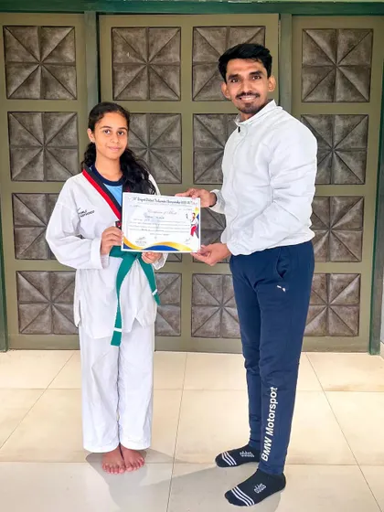 Presenting a certificate to a student, recognizing her hard work and progress.