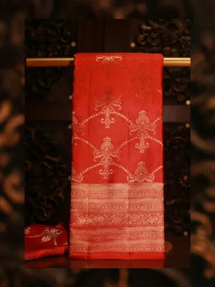 An opulent orange Kanjivaram with intricate silver zari weaving and a heavy brocade border.