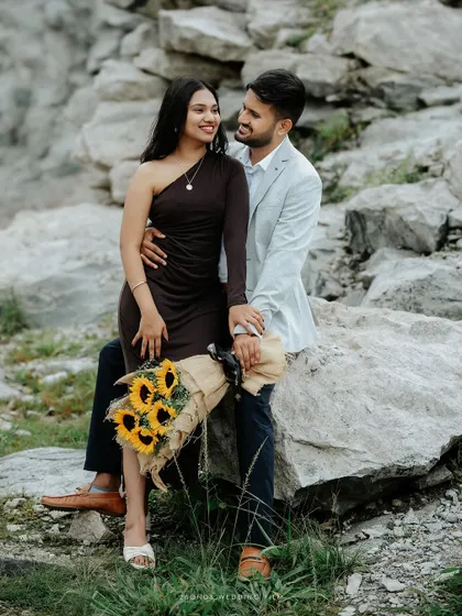 A beautiful portrait of the couple seated on a rock, their loving gaze and the natural backdrop creating a timeless and romantic pre-wedding photograph.