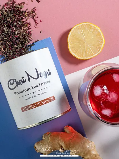 A modern, graphic composition for an iced tea. The diagonal lines and color blocking create a dynamic and stylish look, while the fresh ingredients hint at the flavor.