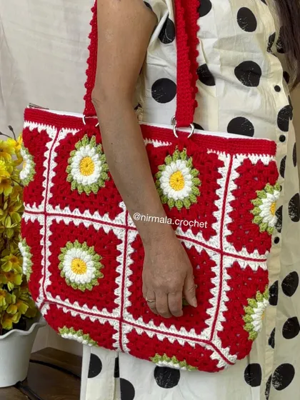 A model showcasing the generous size and comfortable straps of the red daisy tote. It’s a practical and stylish choice for daily use.