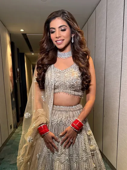 A full-length view of the bride in her stunning silver lehenga. The makeup is perfectly balanced to complement the intricate outfit without overpowering it.