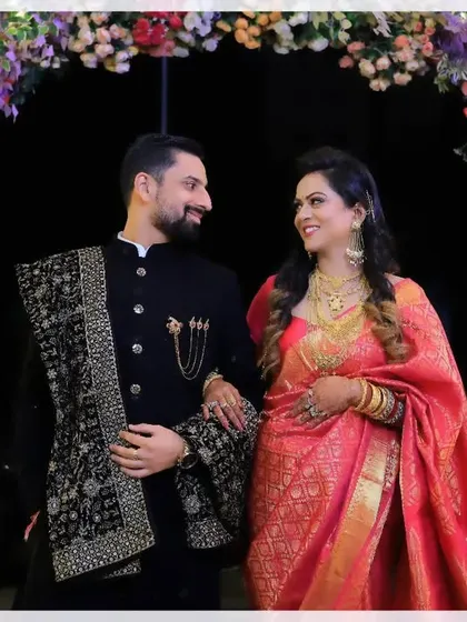 They say it all with their eyes. A beautiful shot of a couple sharing a look under a floral arch, capturing a moment of quiet connection amidst the celebration.