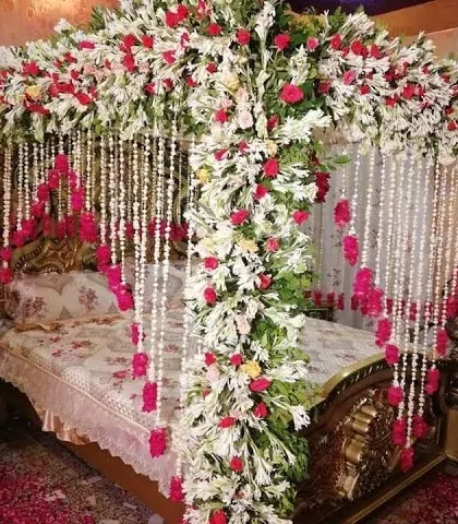 We create romantic settings for your wedding night. This four-poster bed is lavishly decorated with a canopy of white and red flowers and hanging floral strings for an unforgettable first night.