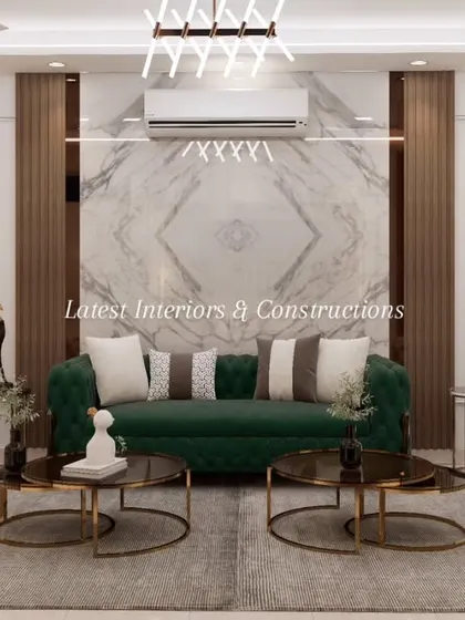 A symmetrical view of a living area defined by its bold color choices and material palette. An emerald green sofa is flanked by two tufted off-white couches, all set against a book-matched marble wall panel framed by dark wood.